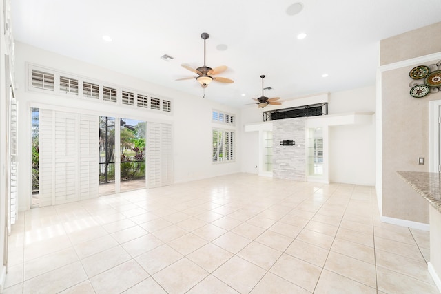 unfurnished living room with ceiling fan and light tile patterned flooring