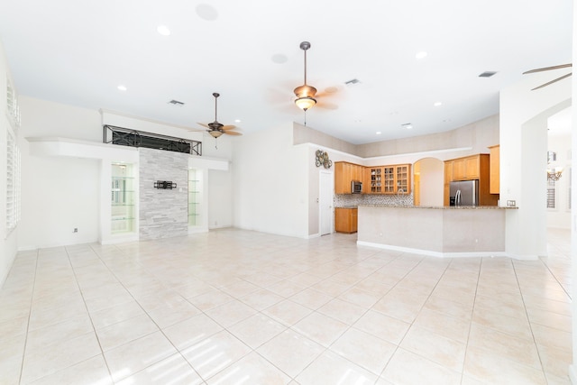 unfurnished living room featuring light tile patterned floors and ceiling fan