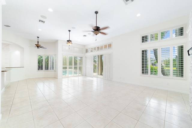 spare room with ceiling fan, light tile patterned flooring, and a wealth of natural light