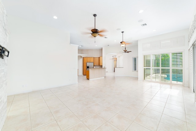 unfurnished living room featuring light tile patterned floors and ceiling fan