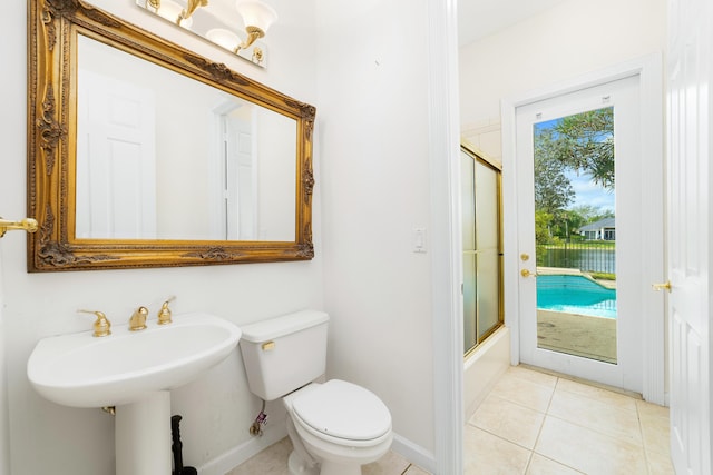 full bathroom featuring tile patterned floors, sink, toilet, and combined bath / shower with glass door