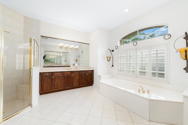 bathroom featuring plus walk in shower, vanity, a healthy amount of sunlight, and tile patterned flooring