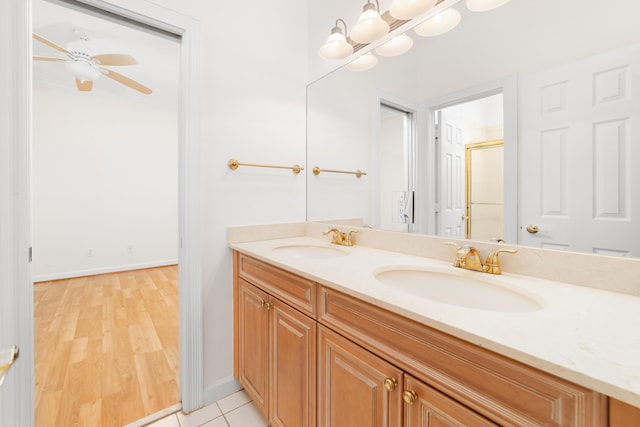 bathroom with hardwood / wood-style floors, ceiling fan, walk in shower, and vanity