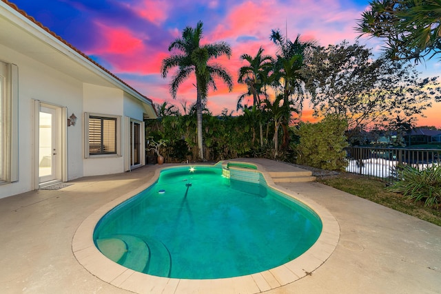 pool at dusk with a patio