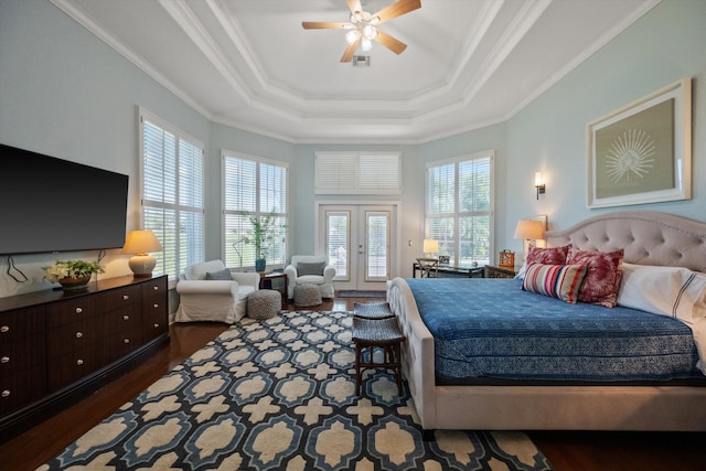 bedroom featuring dark wood-type flooring, french doors, a raised ceiling, ceiling fan, and multiple windows