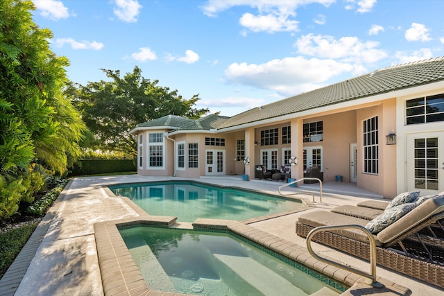 view of swimming pool with a patio area, an in ground hot tub, and french doors