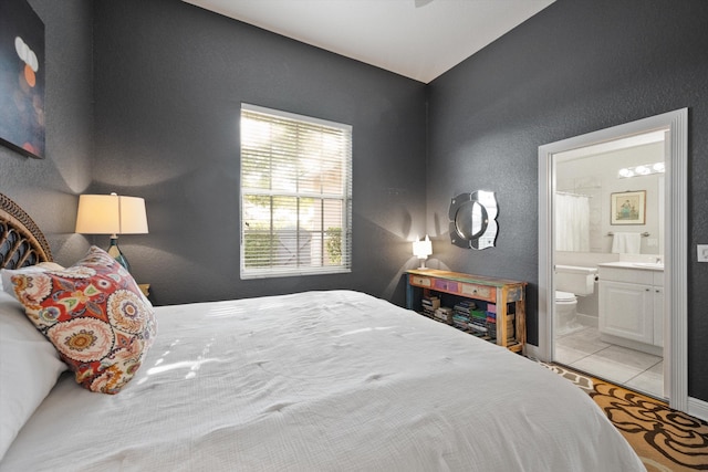 tiled bedroom featuring connected bathroom