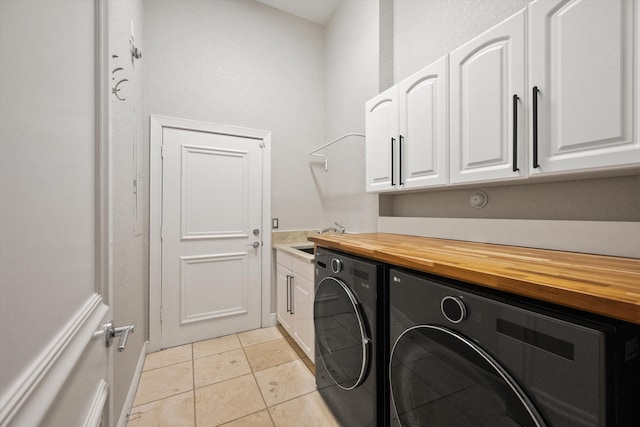 clothes washing area with cabinets, separate washer and dryer, sink, and light tile patterned floors