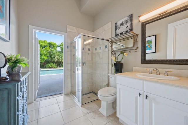 bathroom with tile patterned floors, vanity, toilet, and a shower with shower door