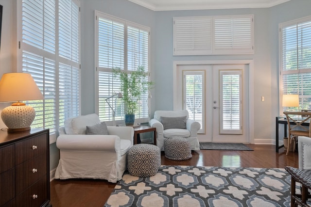 living area featuring dark hardwood / wood-style flooring, a wealth of natural light, french doors, and ornamental molding