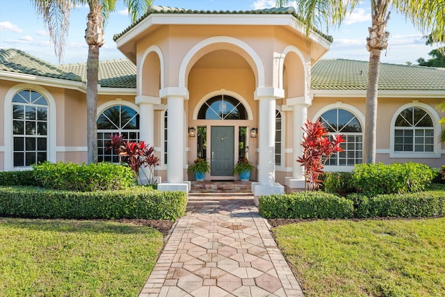 entrance to property featuring a lawn