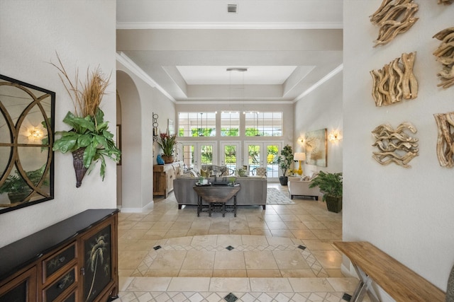 tiled entrance foyer with a raised ceiling, crown molding, and french doors