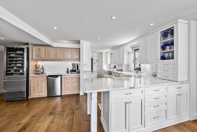 kitchen featuring kitchen peninsula, white cabinetry, light stone countertops, and dark hardwood / wood-style floors