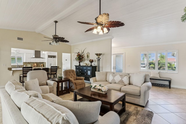 living room with ceiling fan, crown molding, sink, lofted ceiling with beams, and light tile patterned flooring