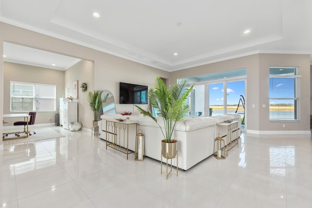 living room with a tray ceiling, a healthy amount of sunlight, and ornamental molding