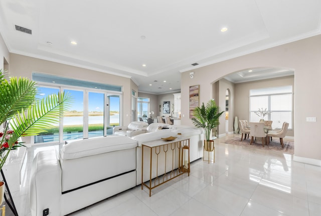 tiled living room featuring a water view, plenty of natural light, and ornamental molding