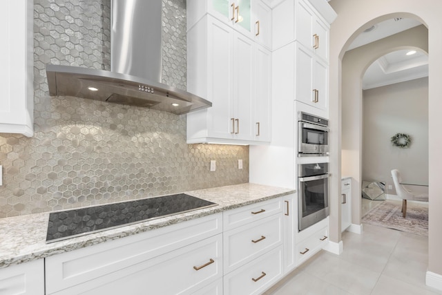 kitchen featuring black electric cooktop, white cabinetry, and wall chimney range hood