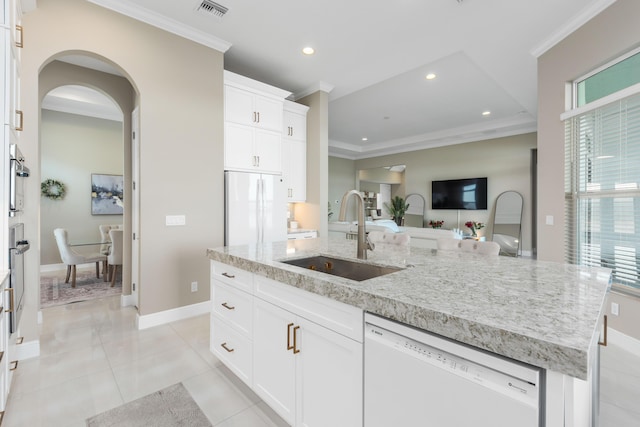 kitchen with a kitchen island with sink, sink, white cabinets, and white appliances