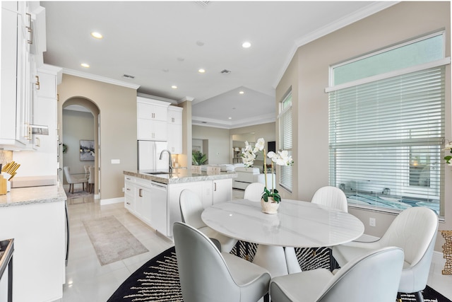 dining space featuring sink, light tile patterned floors, and ornamental molding