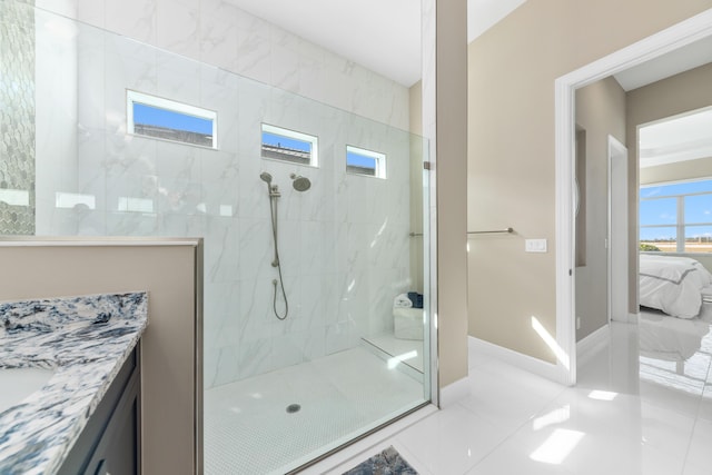 bathroom featuring tile patterned floors, vanity, and a tile shower