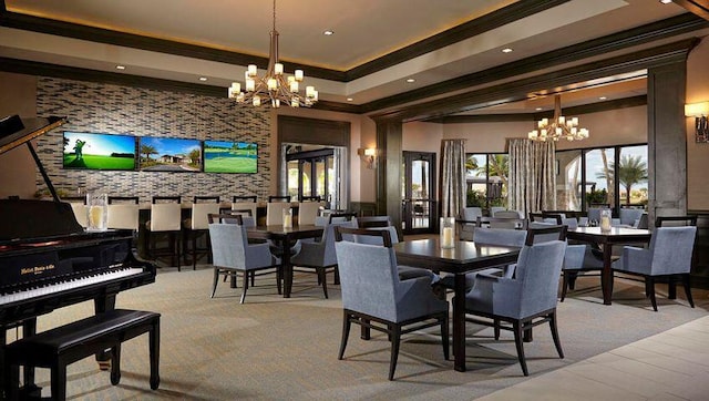 dining room featuring a raised ceiling, ornamental molding, and an inviting chandelier