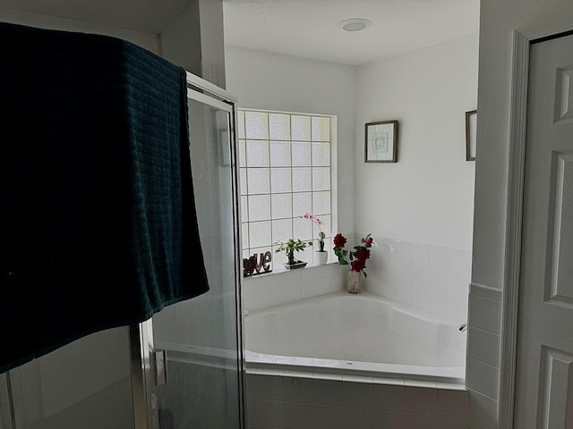 bathroom featuring shower with separate bathtub