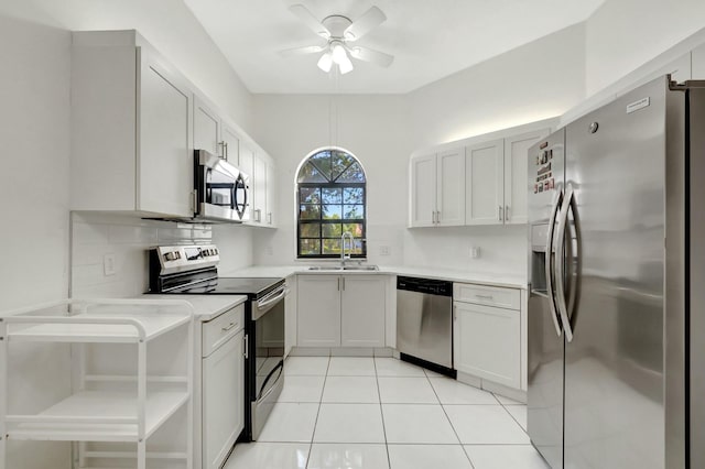 kitchen with a sink, stainless steel appliances, light tile patterned flooring, light countertops, and ceiling fan