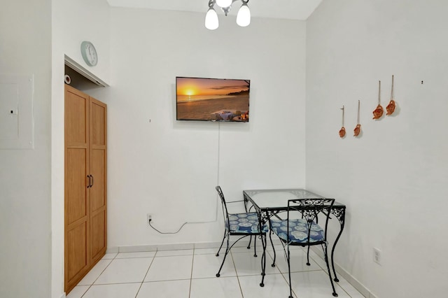 dining room featuring electric panel, baseboards, and light tile patterned floors