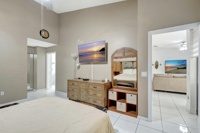 bedroom with light tile patterned flooring, baseboards, and a towering ceiling