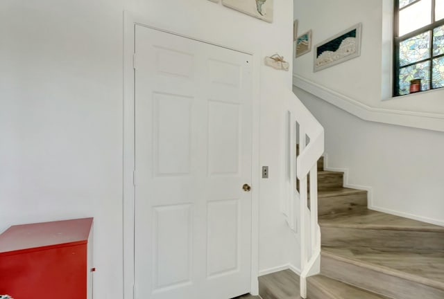 staircase with baseboards and wood finished floors