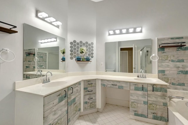 full bath with tile patterned floors, two vanities, walk in shower, and a sink