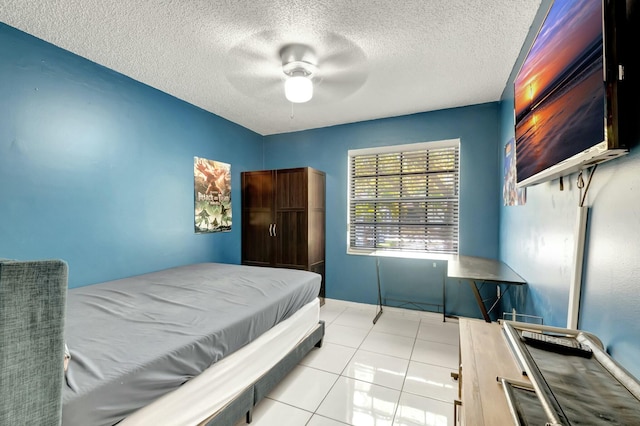 bedroom with light tile patterned flooring, a textured ceiling, and a ceiling fan