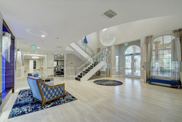 interior space featuring stairway, an inviting chandelier, french doors, and visible vents