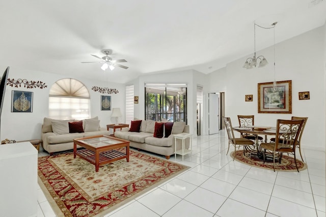 living area with light tile patterned floors, ceiling fan with notable chandelier, and vaulted ceiling