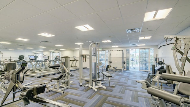 workout area with visible vents, a paneled ceiling, and carpet flooring