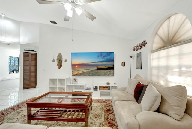 living room with tile patterned floors, visible vents, baseboards, ceiling fan, and vaulted ceiling