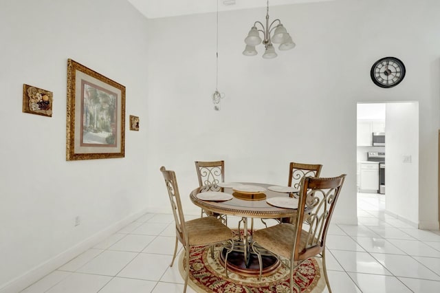 dining space with light tile patterned flooring, a notable chandelier, baseboards, and a towering ceiling