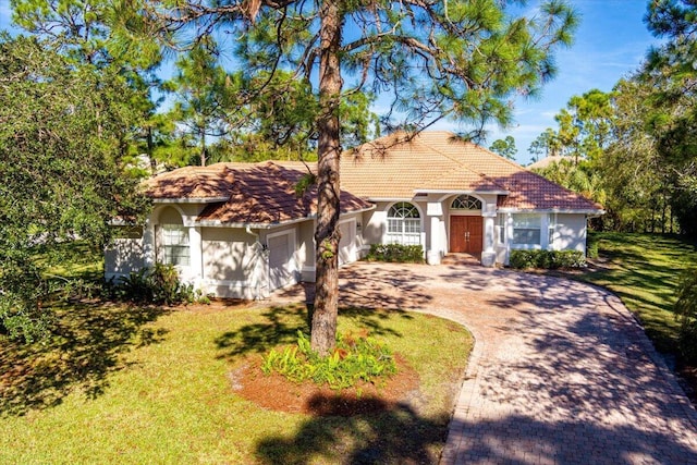 mediterranean / spanish-style home with a garage and a front yard