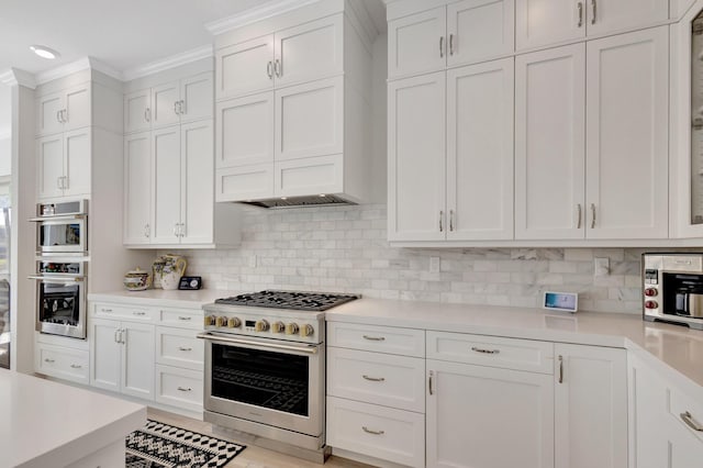 kitchen with stainless steel appliances, white cabinetry, tasteful backsplash, and crown molding