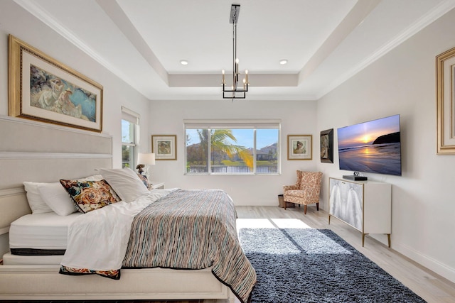 bedroom with a raised ceiling, crown molding, a notable chandelier, and light wood-type flooring