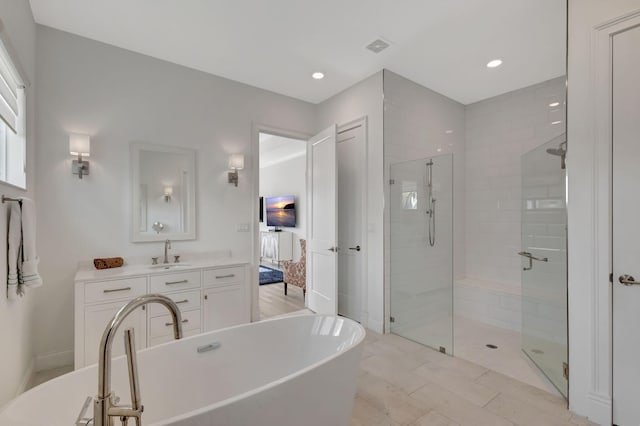 bathroom featuring vanity and separate shower and tub