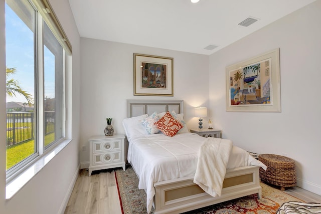 bedroom featuring multiple windows and light hardwood / wood-style flooring