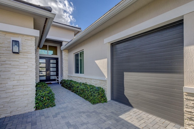 view of exterior entry featuring french doors and a garage