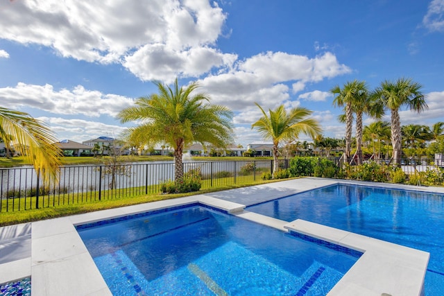 view of swimming pool with an in ground hot tub and a water view