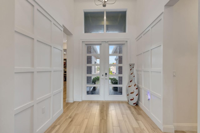 entryway with french doors and light hardwood / wood-style floors