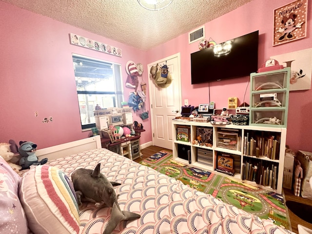 bedroom with wood-type flooring and a textured ceiling