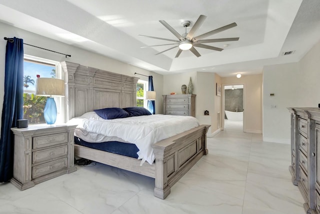 bedroom with ceiling fan, a tray ceiling, and multiple windows