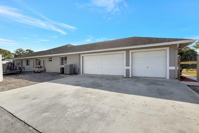 ranch-style house with a garage and central air condition unit