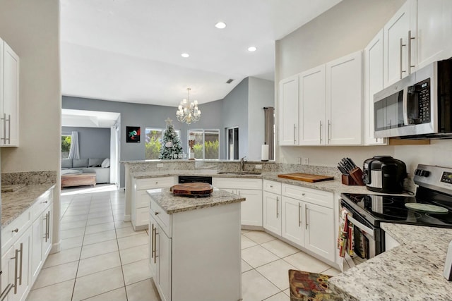 kitchen with sink, hanging light fixtures, an inviting chandelier, light stone counters, and appliances with stainless steel finishes