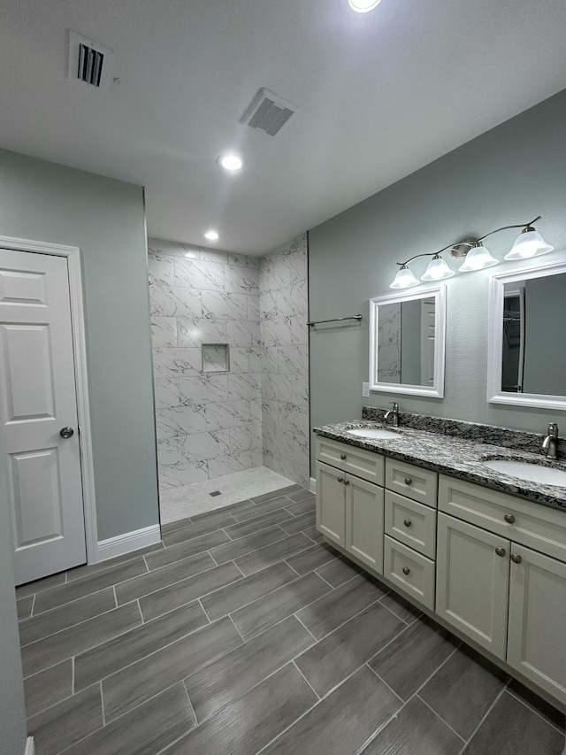 bathroom featuring vanity and tiled shower